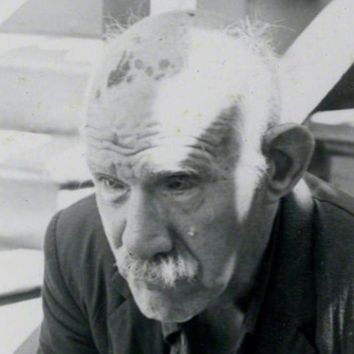  Old man with white moustache looking down 