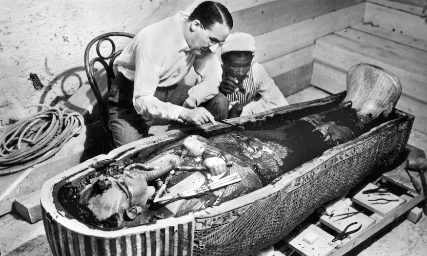 two men looking at sarcophagus