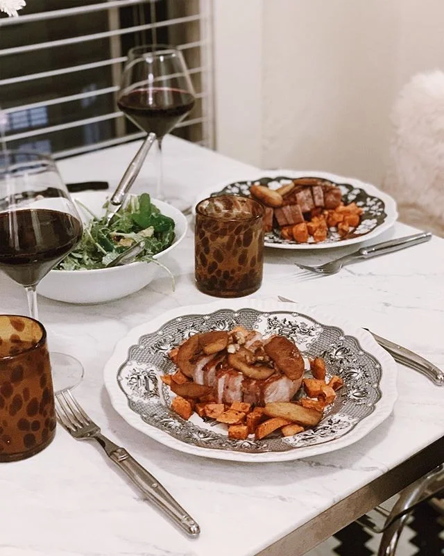 Dinner is served. Pan seared pork chops with brown butter apples over roasted sweet potatoes and salad. Oh and some vino on the side.