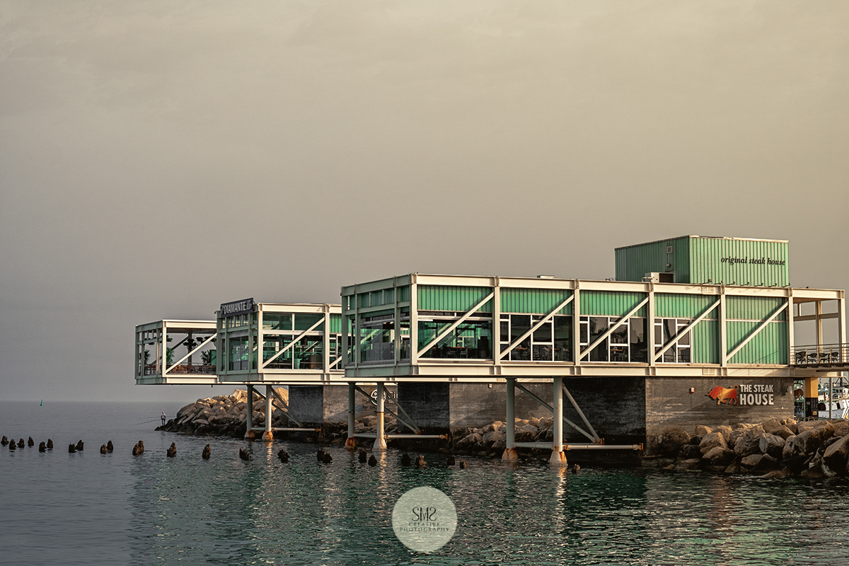 The cold and cloudy light just before the 'golden hour' falling on this restaurant at Larnaca Marina, Cyprus.