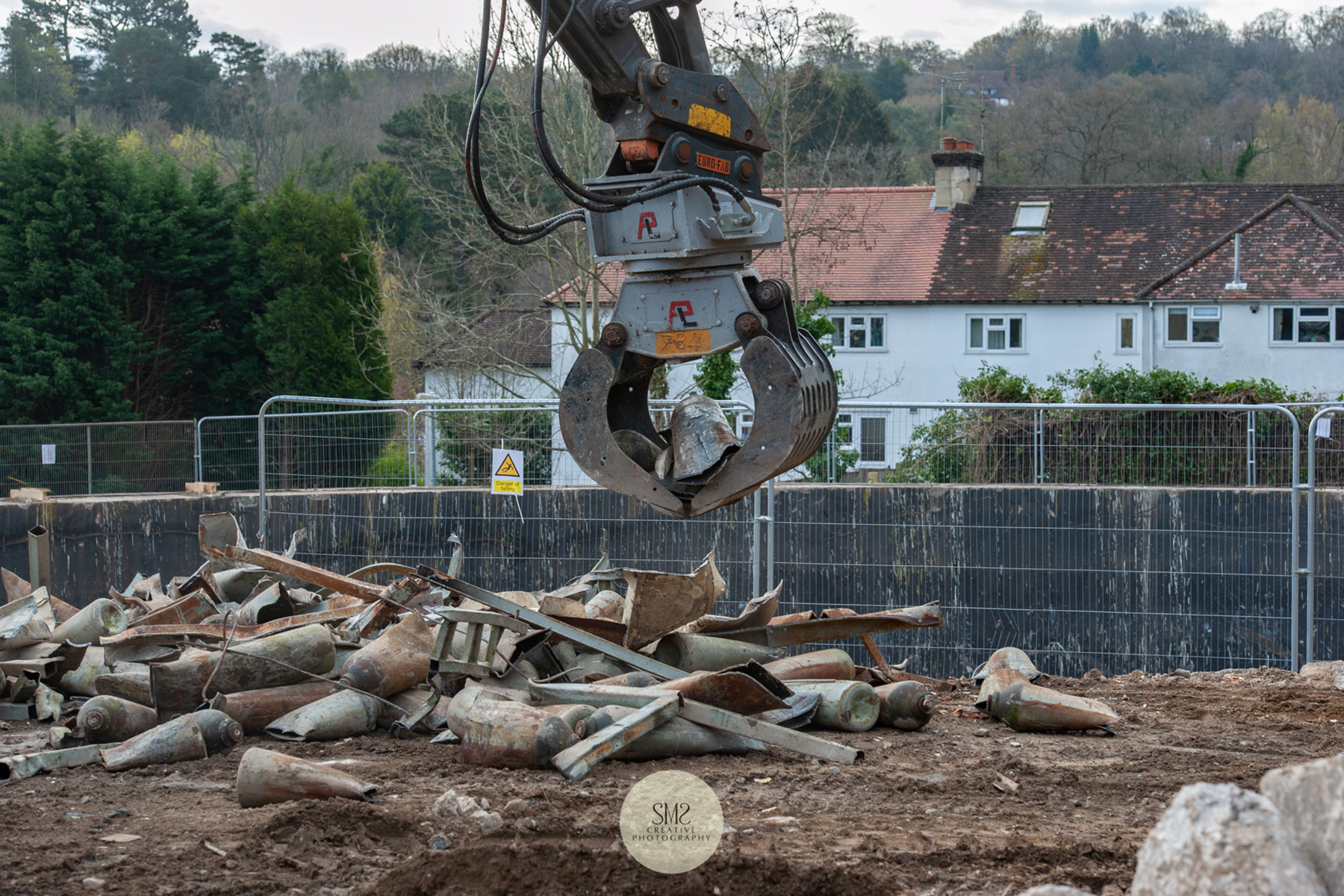 Two machines work in unison cutting and picking up the pieces for recycling.