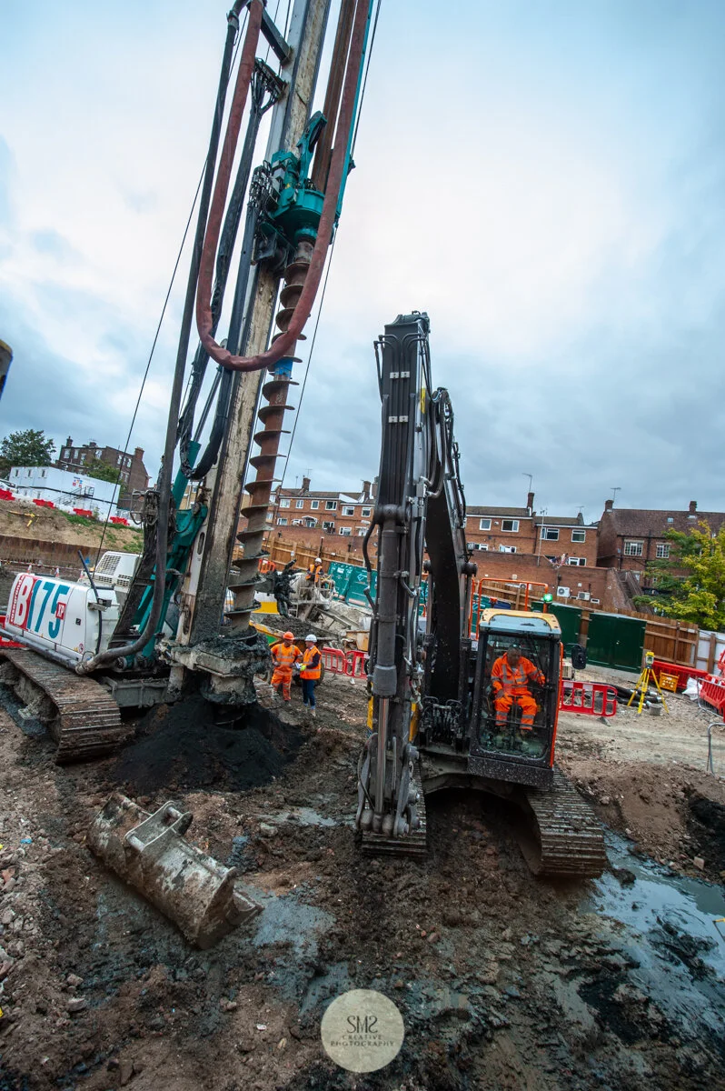On the left the auger on the piling rig that drills out the ground to make way for the concrete.