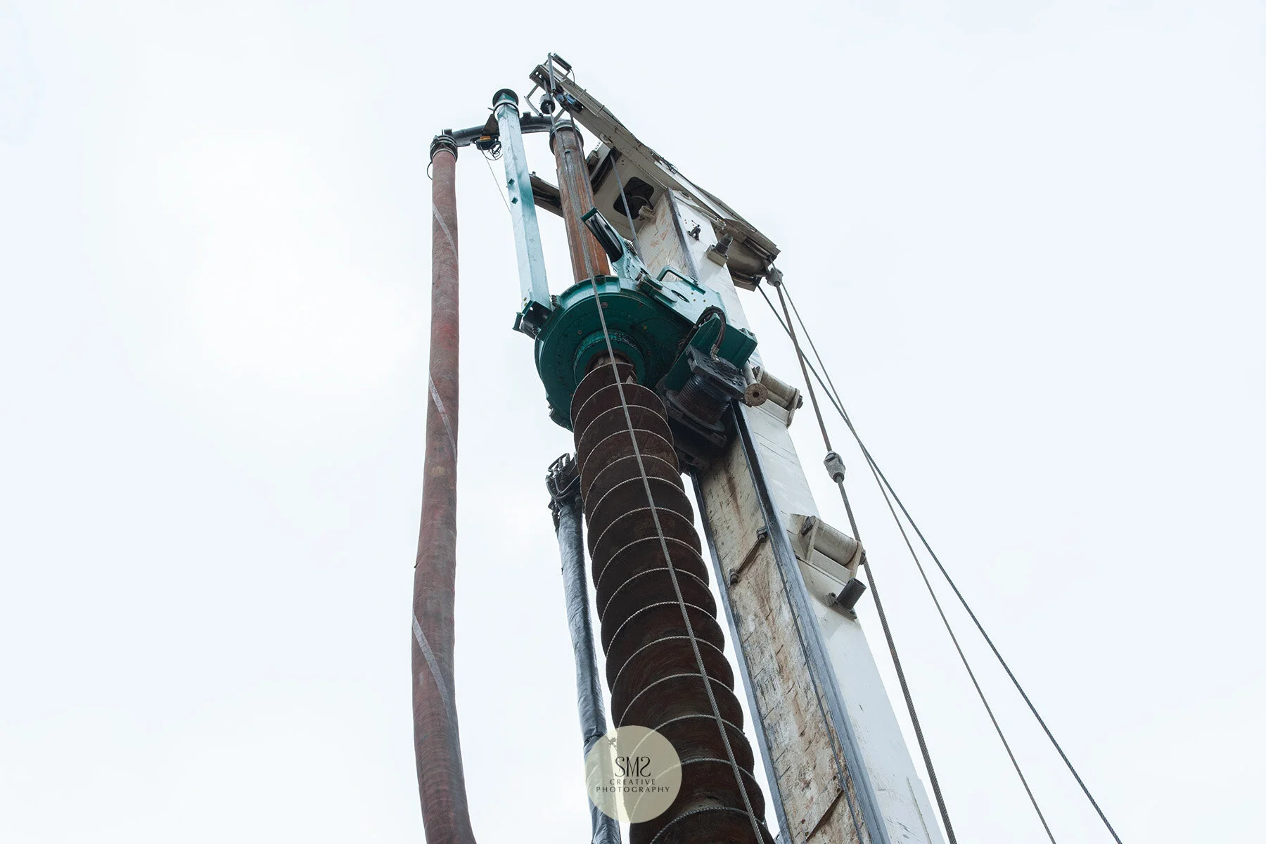 The hose at the top of the auger works in unison with the drill, a swift process in preparation for a metal ‘cradle’ to be inserted in the hole.