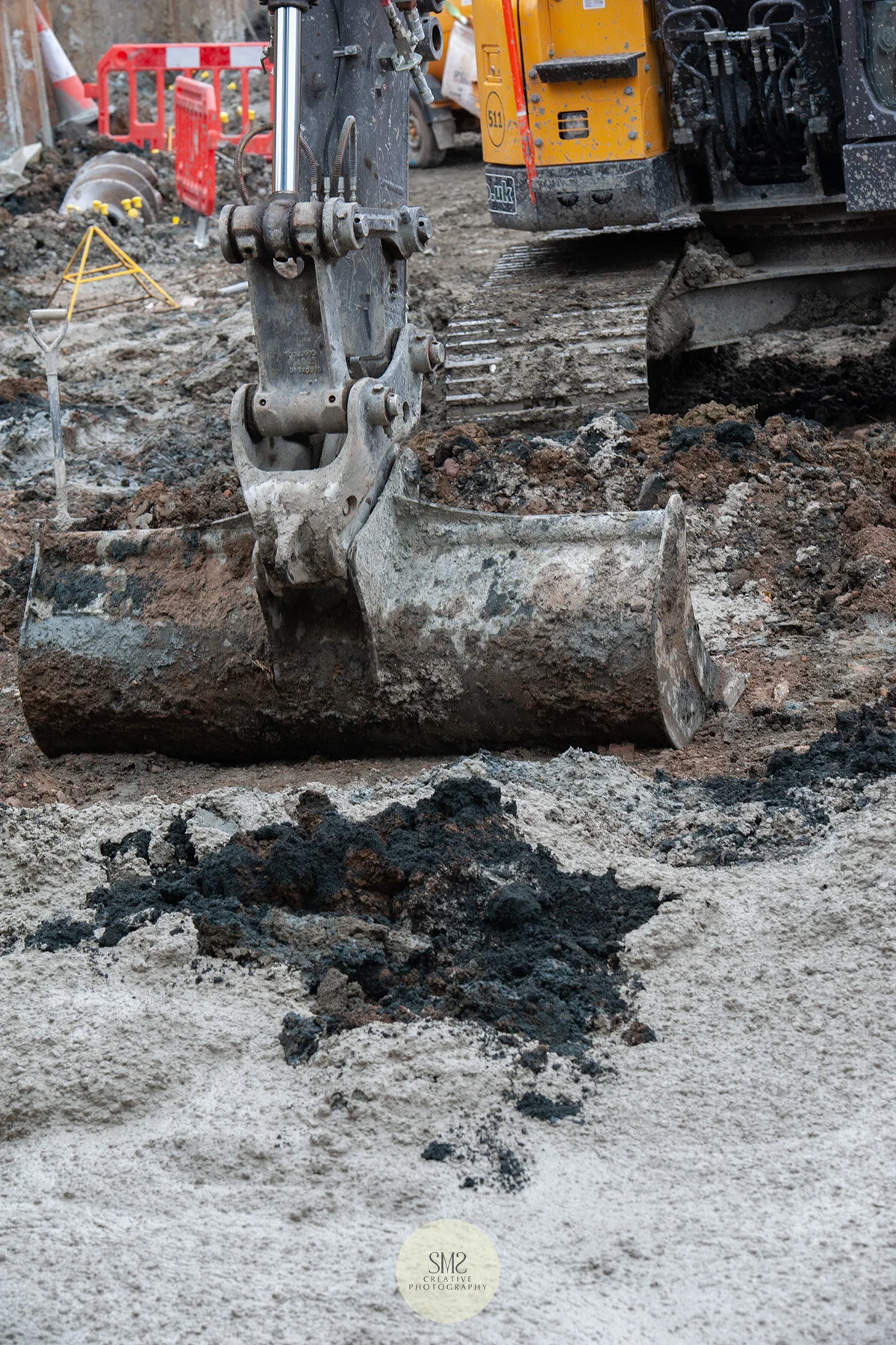 Excess cement and earth is scooped away by the digger.