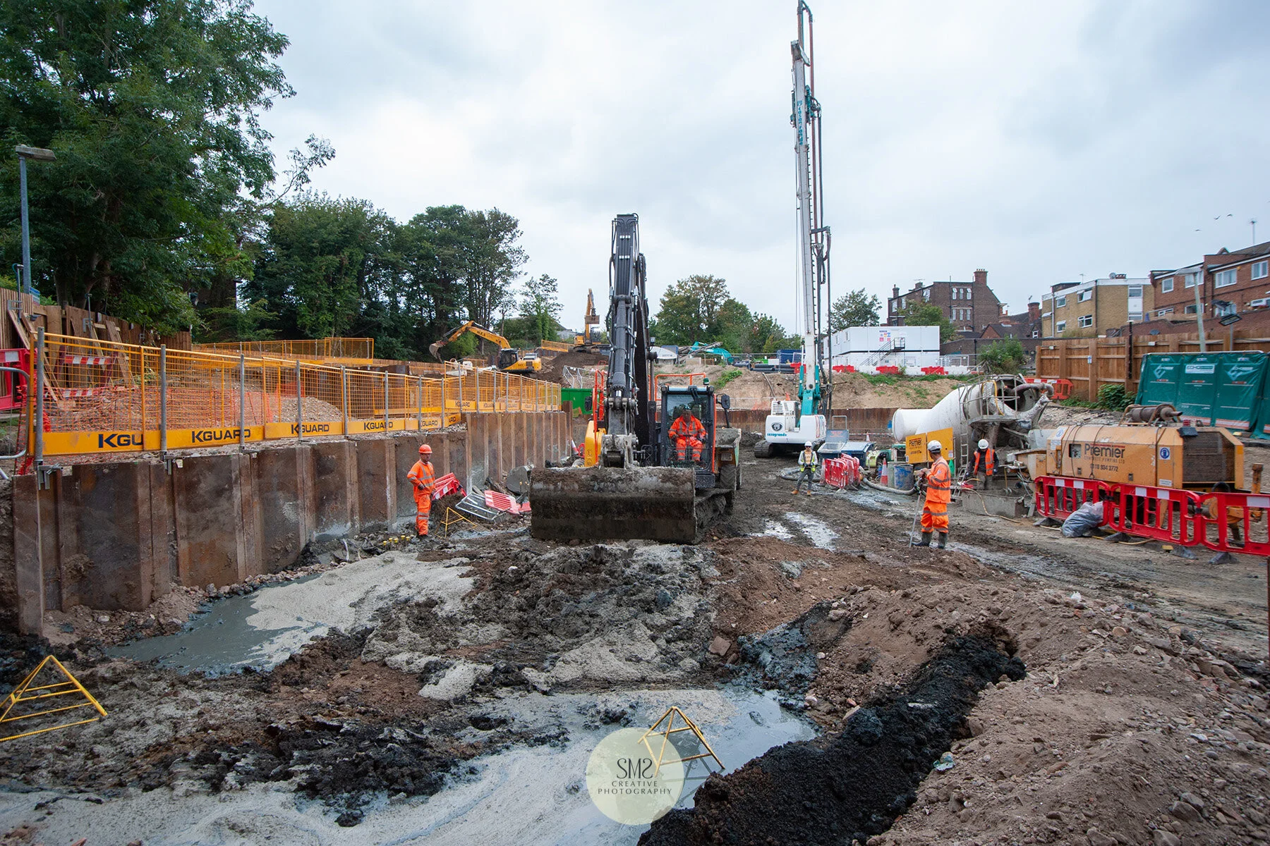 The digger scoops away the excess concrete from the surface.