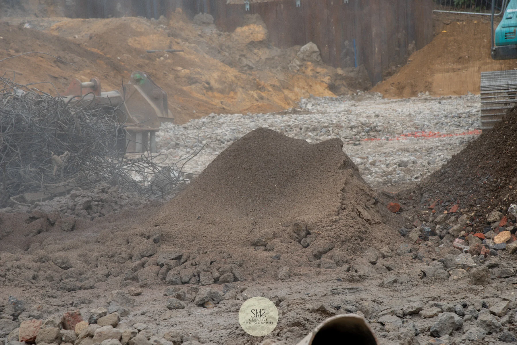 The settled dust seen at the centre of the picture and the crushed concrete on the right which is reused onsite to form the remaining piling mats.
