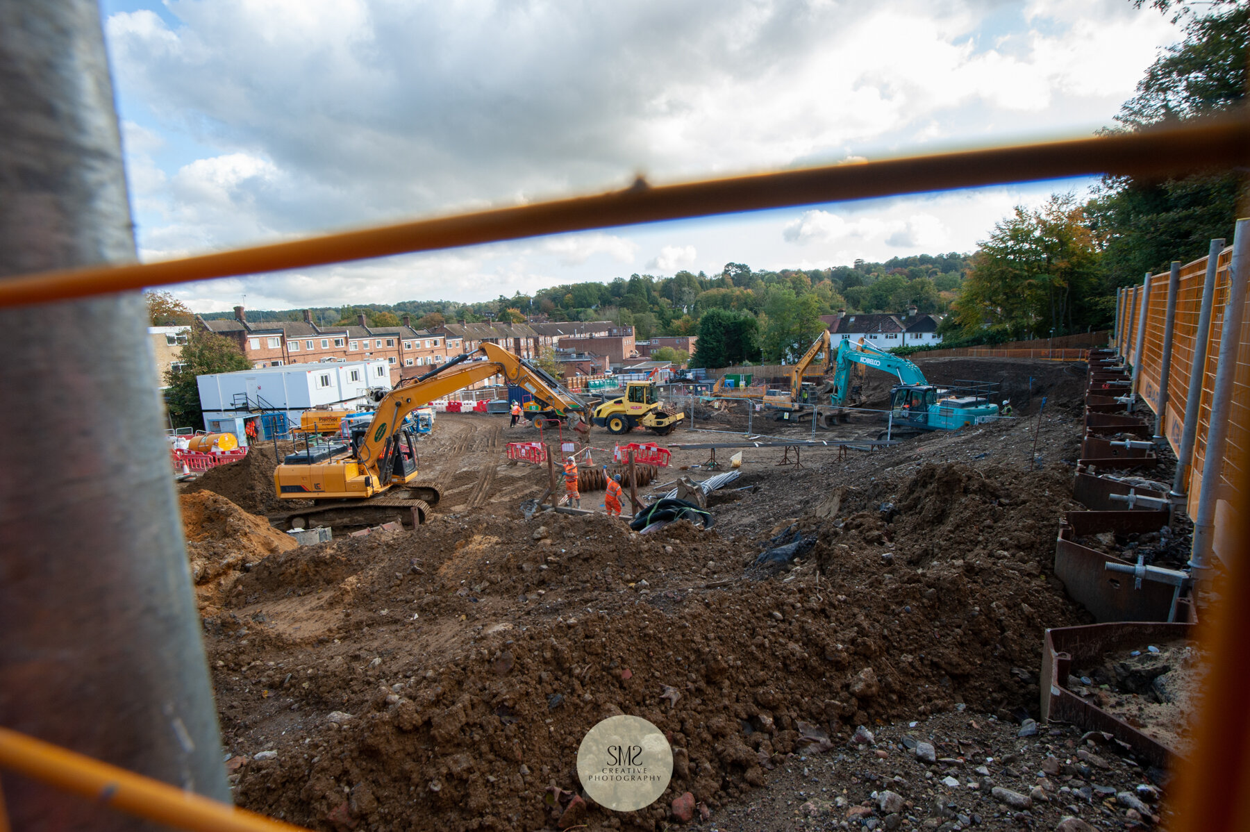  Photographed from the narrow walkway on the perimeter of the site looking through the protective barriers. On the right the top of the sheet piling is visible at ground level. 