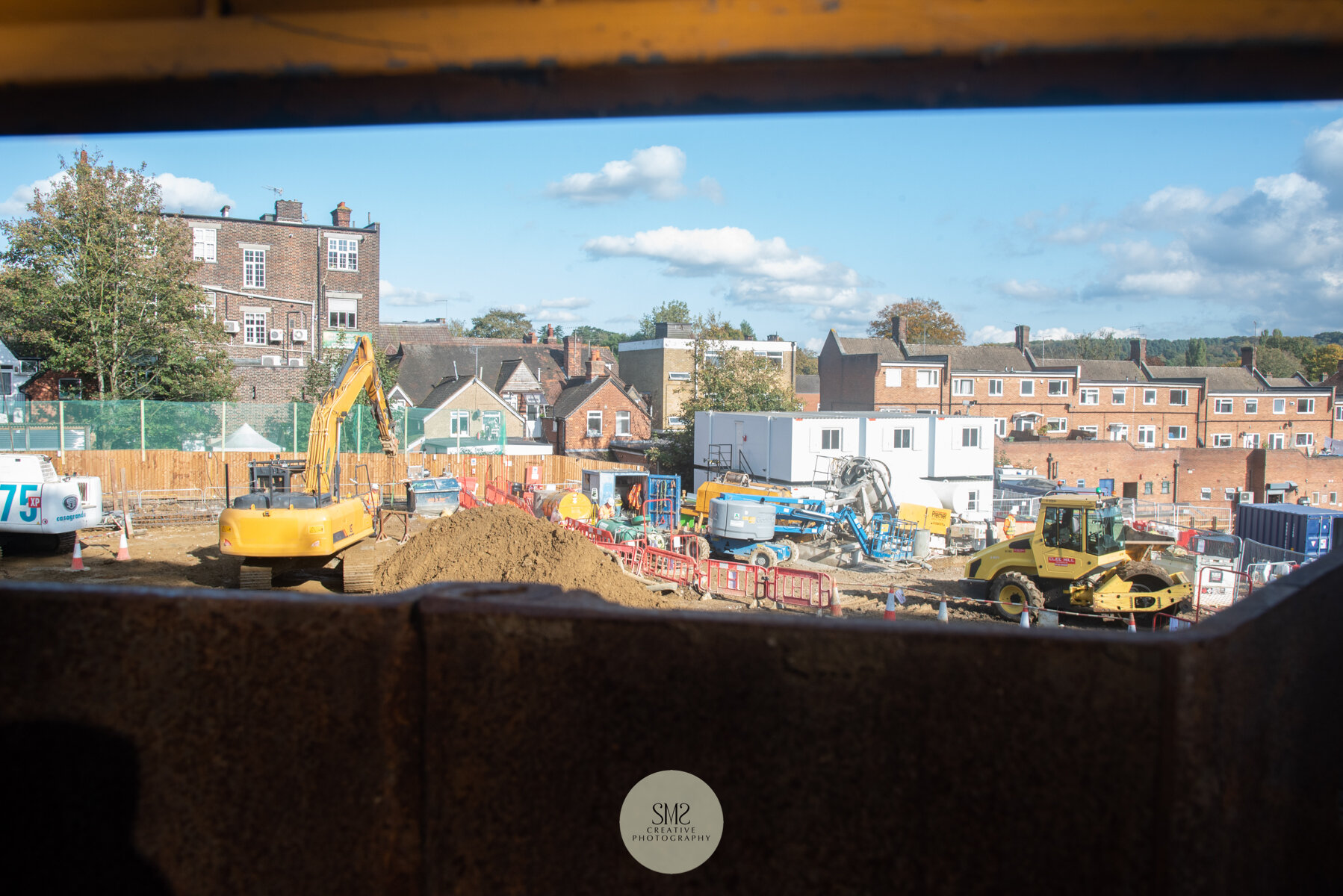  A view between the sheet piling and the safety fence, looking over the building site towards the back of Station Road East. 