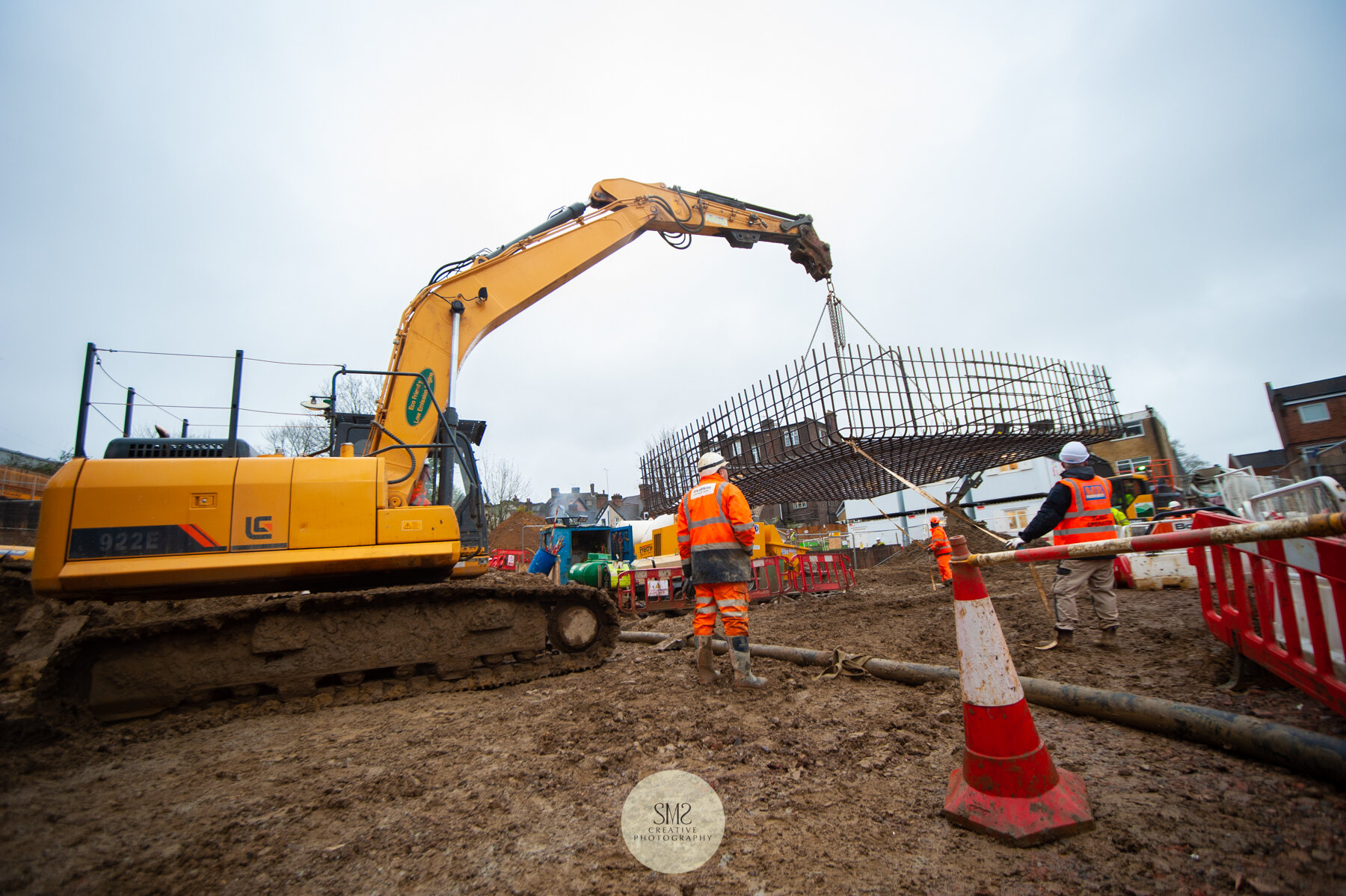  With careful guidance, the cage is lifted in preparation for insertion in the concrete laid pit. 