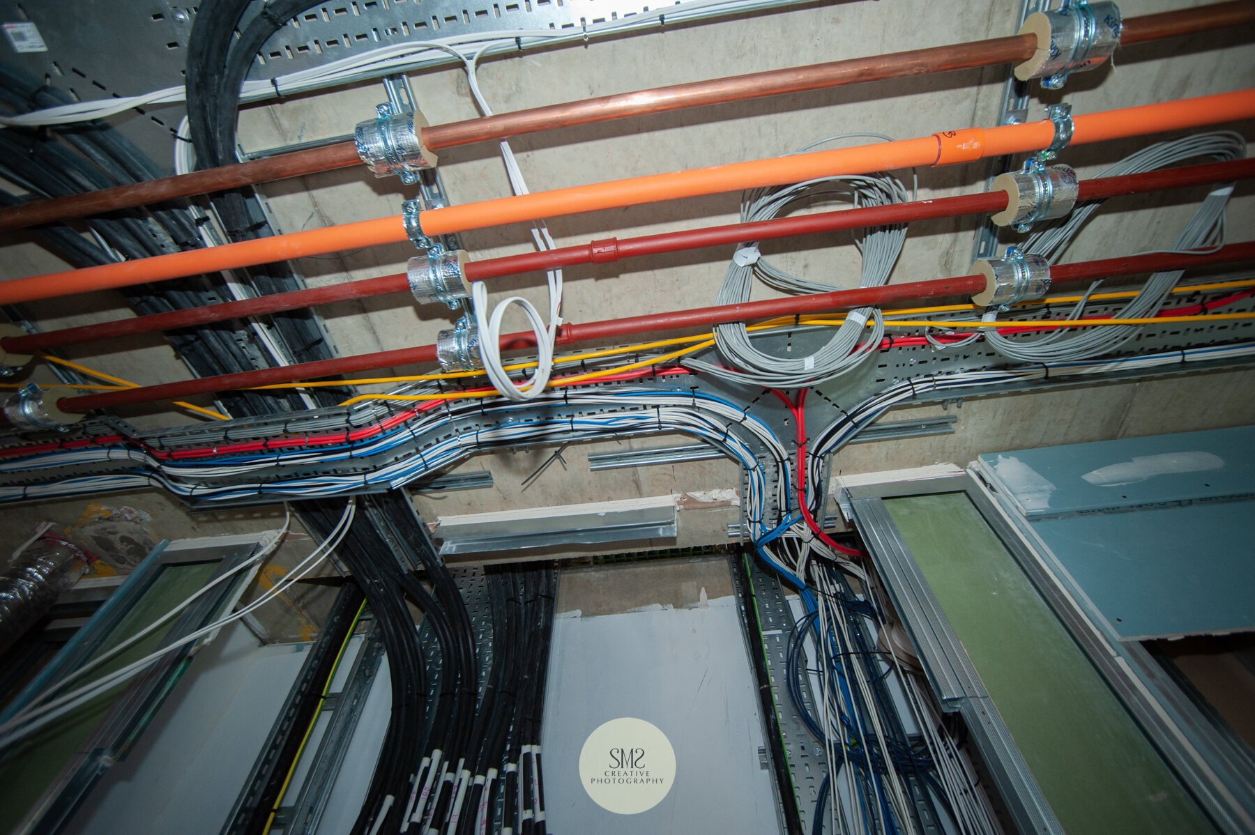 Electrical cable and pipework in the ceiling recess of a corridor in Block A. 