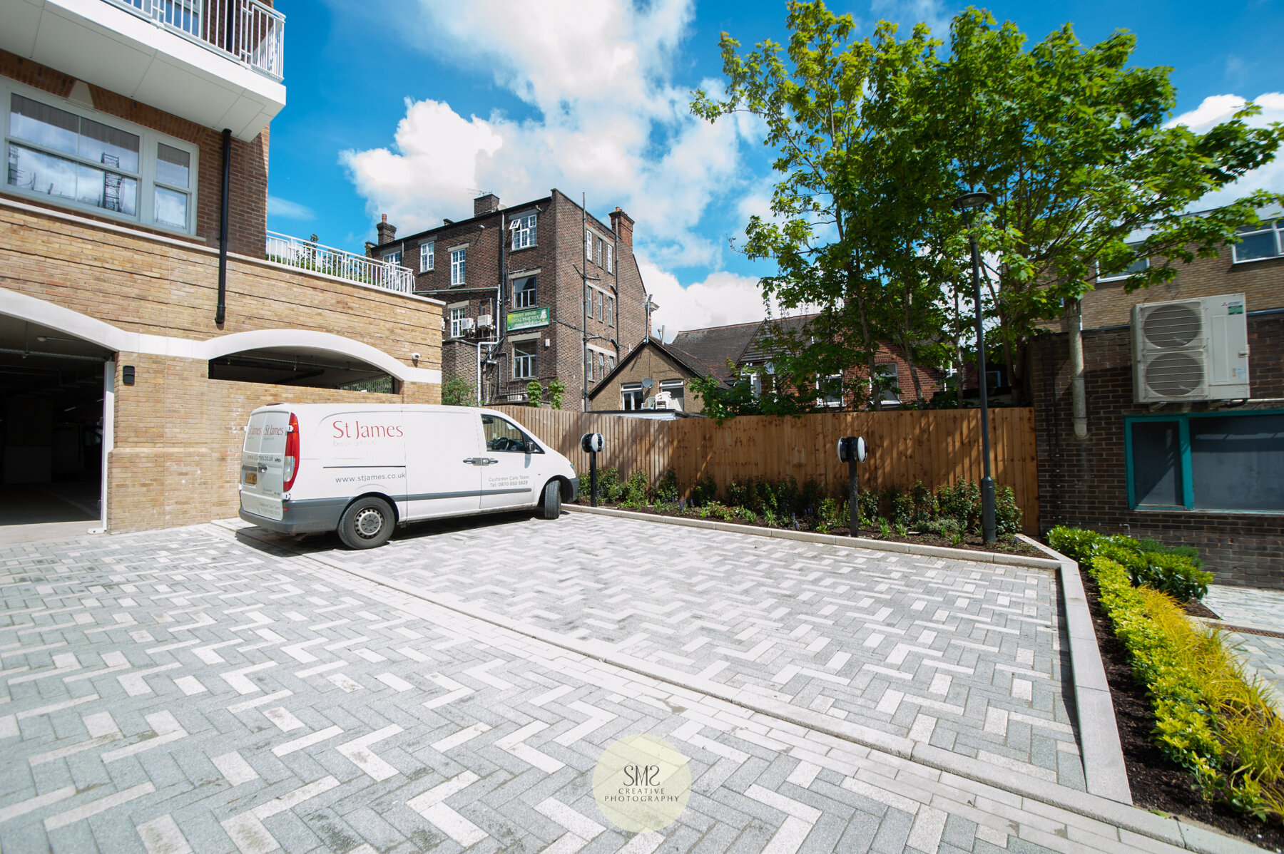  The finished paved forecourt with parking and electric charging points for cars. 