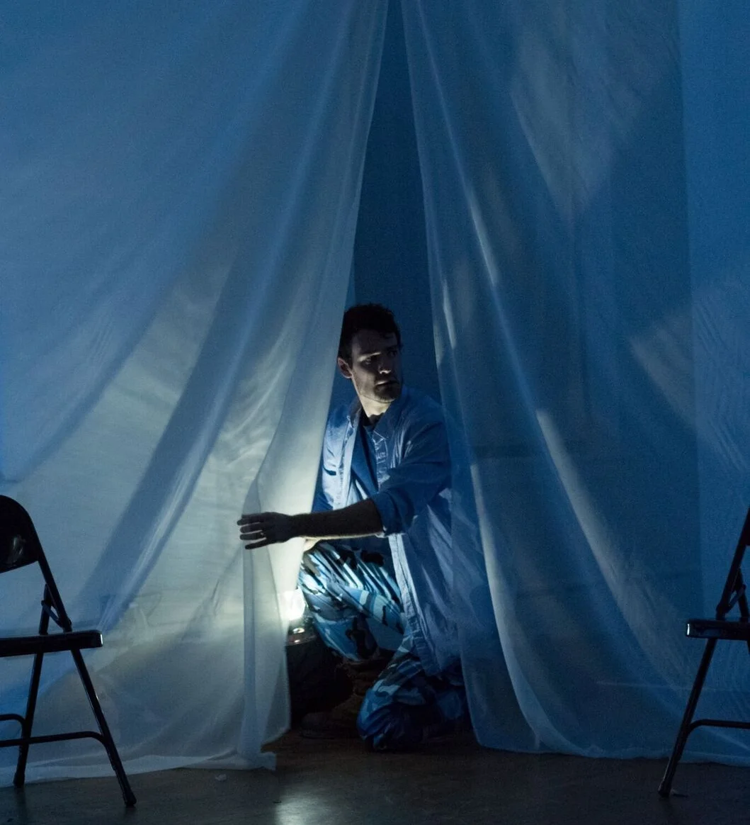Woodrow as Iago crouching over the body of Roderigo in Match: Lit Theater's 2016 production of Othello.