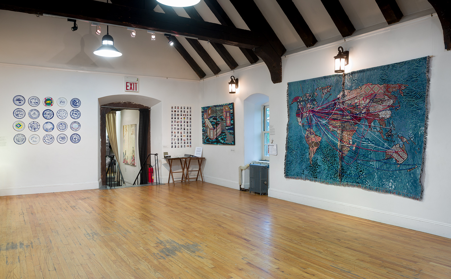  Installation view of "Our Stories of Migration" digital tapestry, student photo grid, mapping binder, and "Visual Heteroglossia: Excavation of the Gentry"  Photo credit: Etienne Frossard 