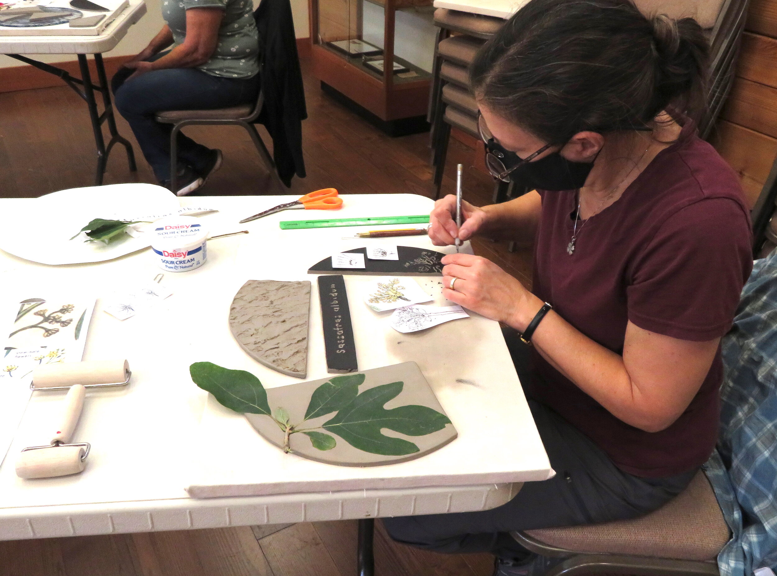  Margaret working on a sgraffito drawing of the Sassafras tree flower. 
