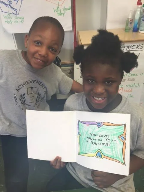 Two beautiful faces from the Detroit Achievement Academy with the "You=Love" coloring book.