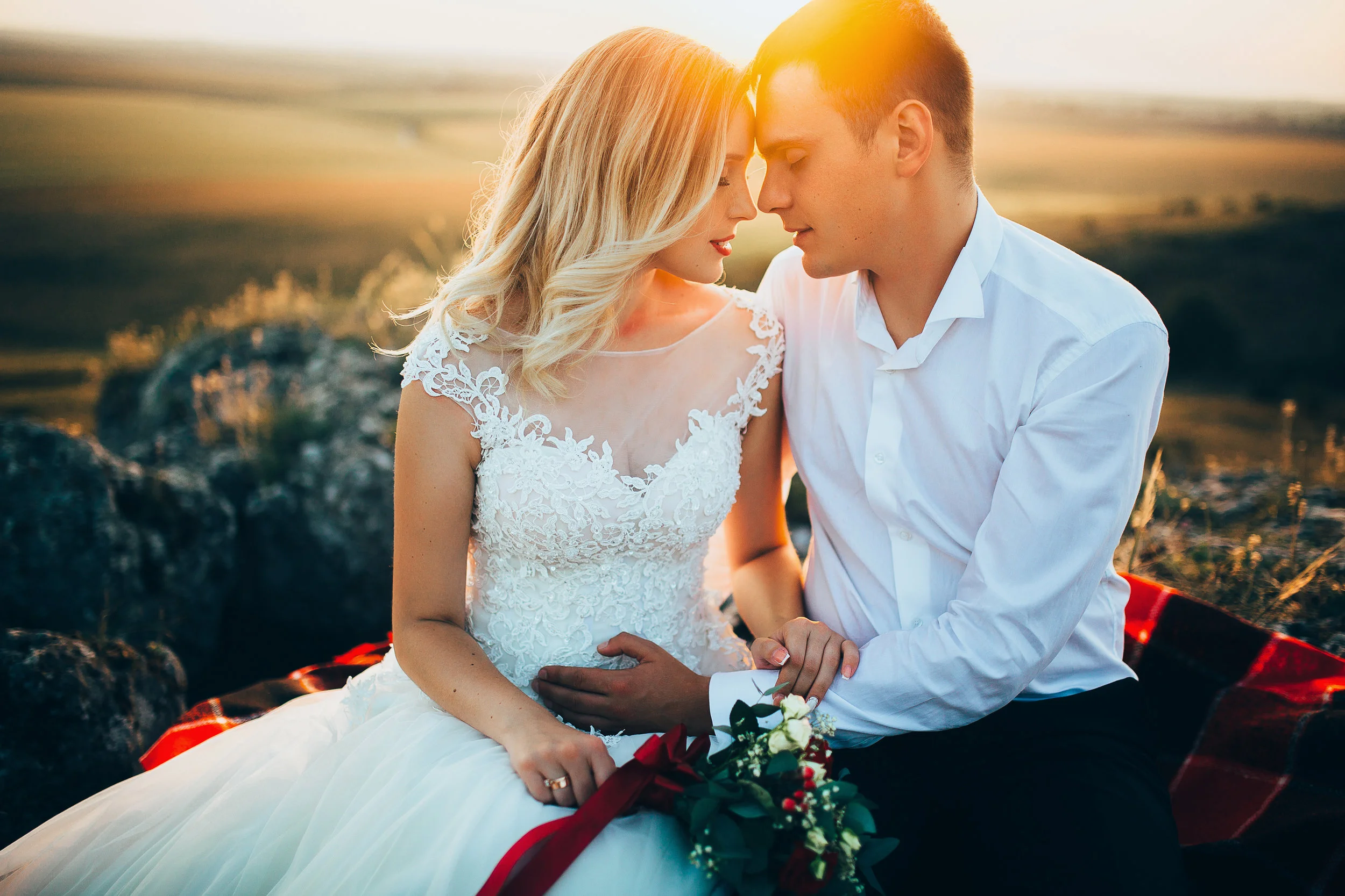 Gorgeous bride, groom kissing and hugging near the cliffs with stunning views