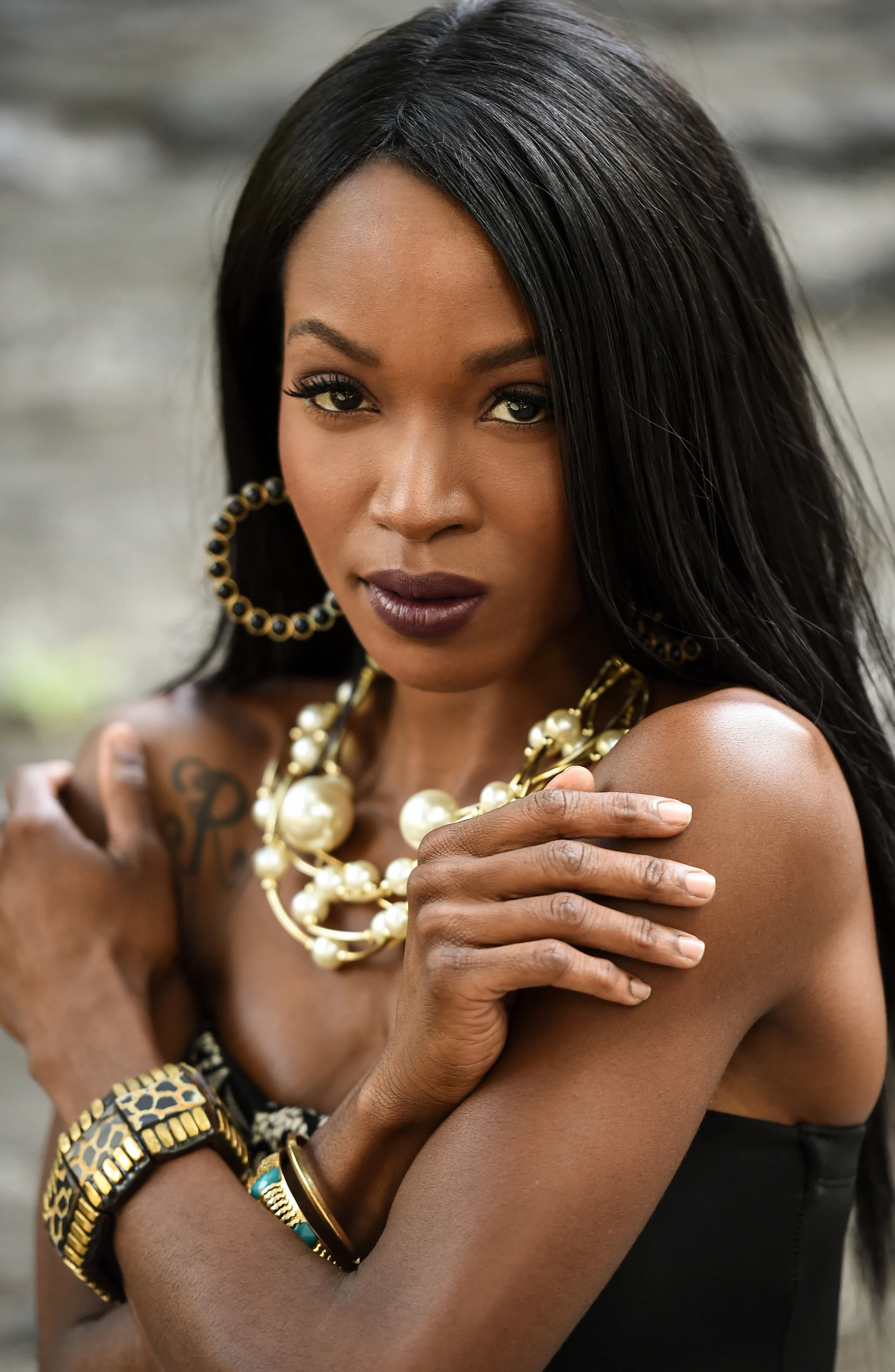 Fashion photo of beautiful elegant african american woman. Girl posing in jewelry, wearing fashionable earrings and necklace. Beauty portrait. Outdoor shot.
