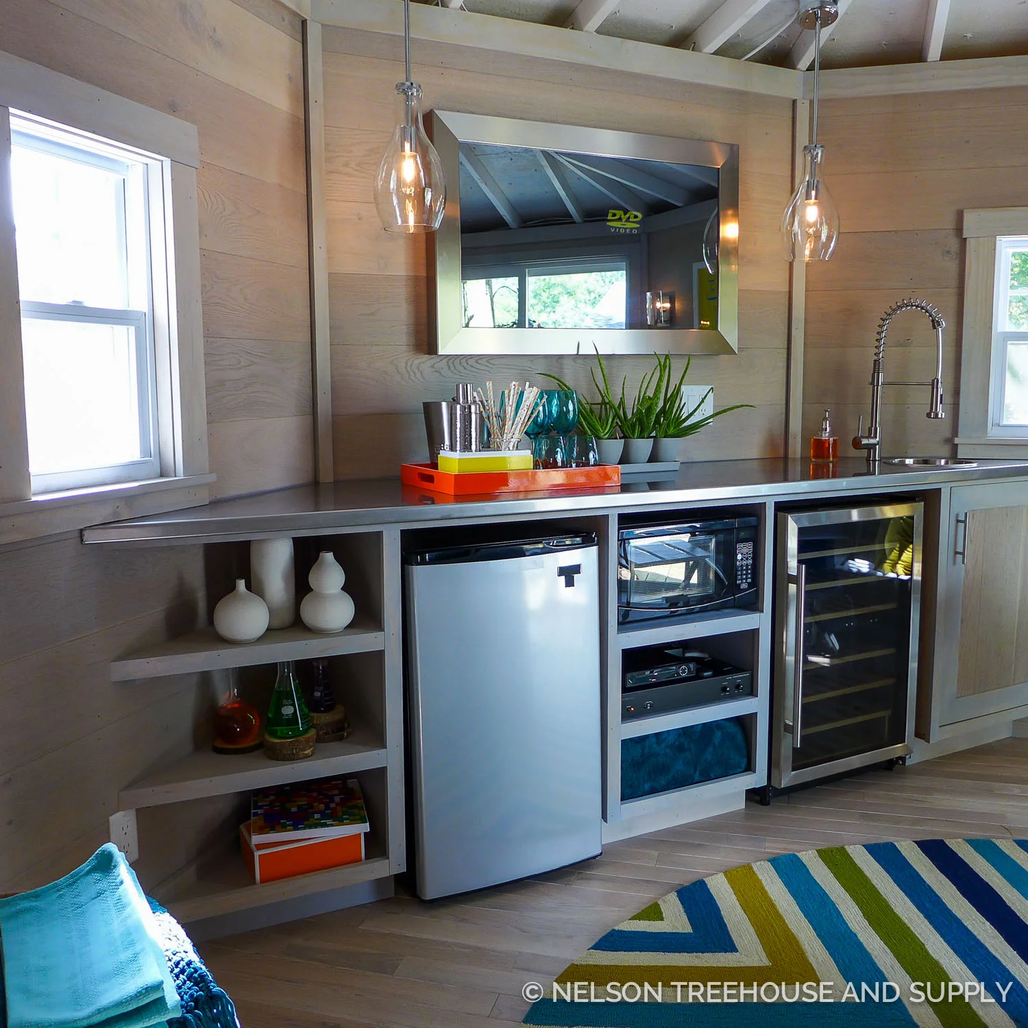 With its clean, stainless steel countertop, this wet bar hints at a chemist's laboratory. The pops of color keep it fun and cheery.