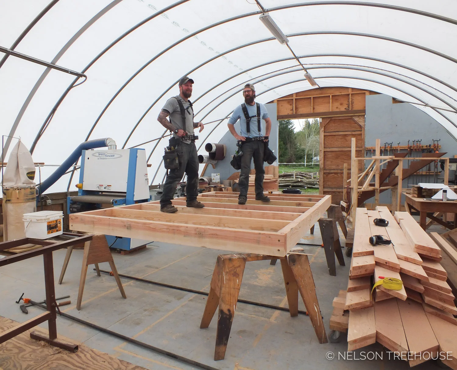 PRefab carpenters Rolf and Griffin testing the strength of their innovative dovetail joinery in a treehouse loft platform.