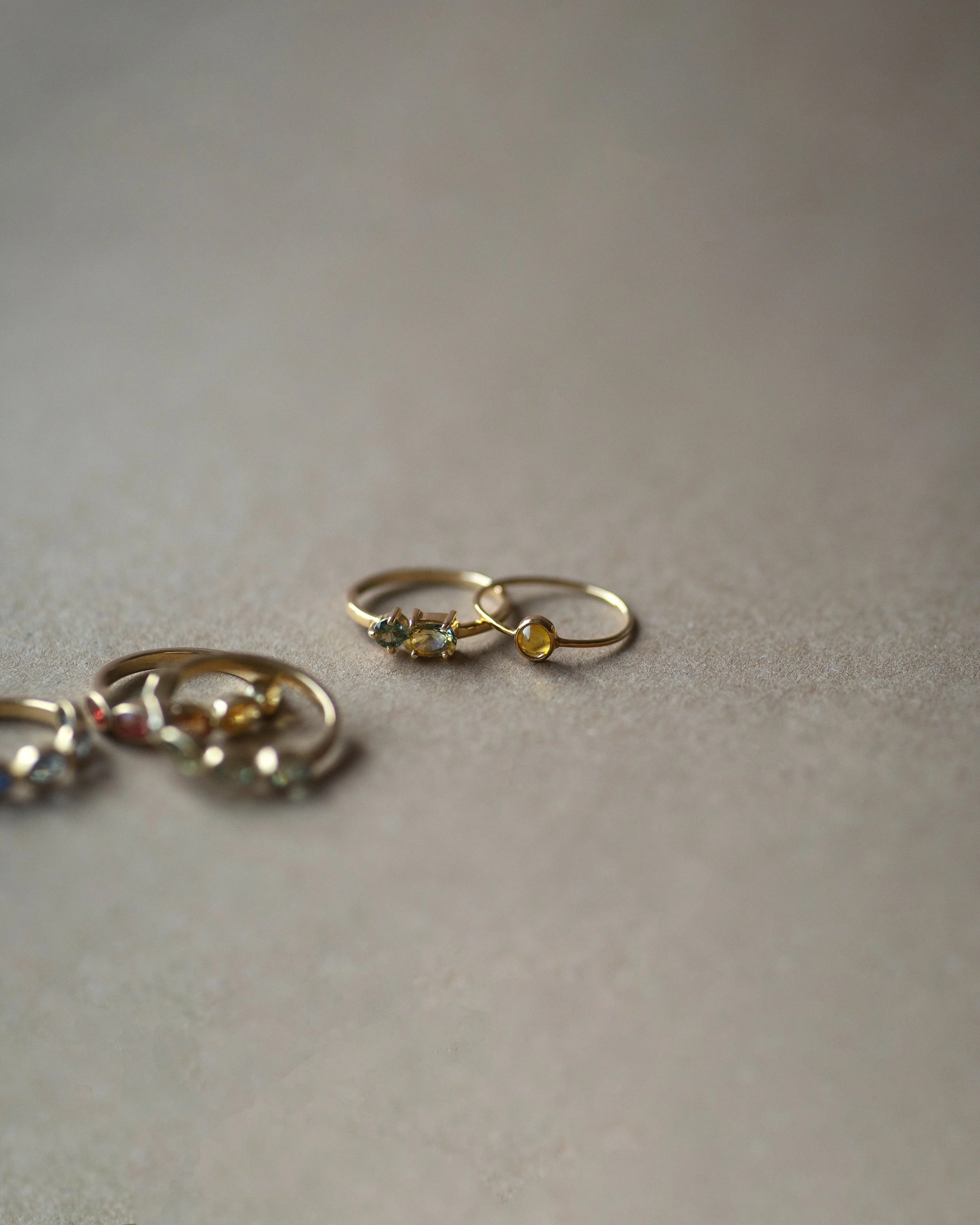 Anillos Nua con zafiro bicolor y zafiro teal y Valentina con zafiro amarillo en oro de 18kt.