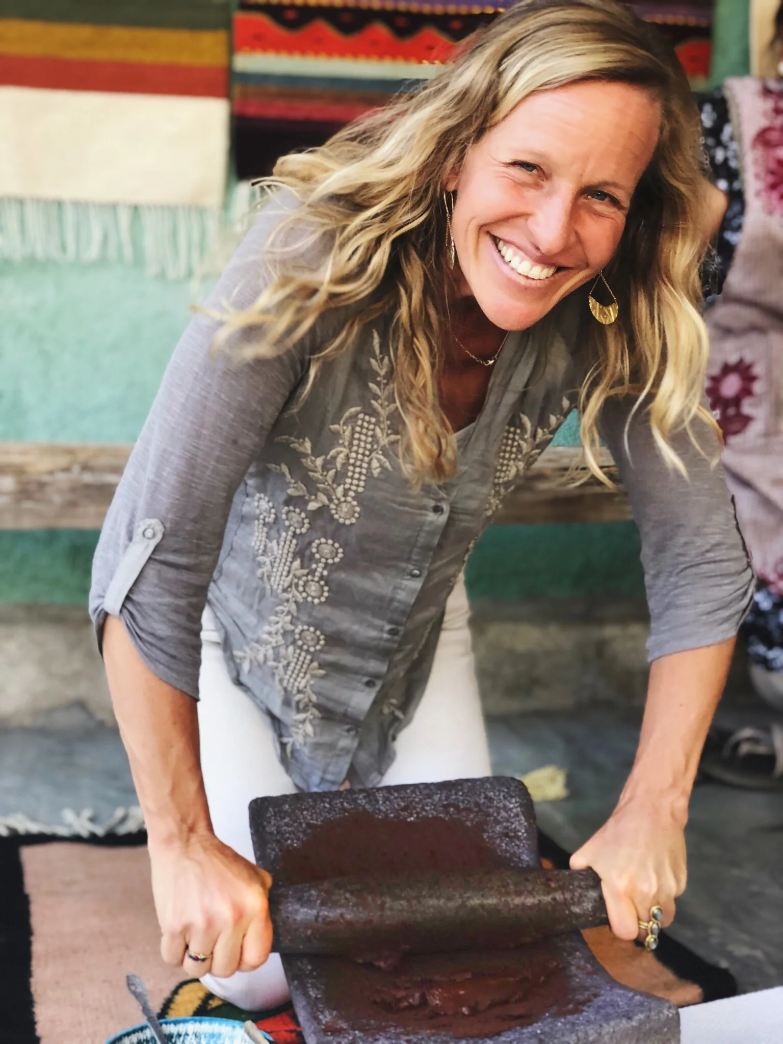 Grinding cacao beans on a stone metate, the traditional way, in Oaxaca, Mexico.
