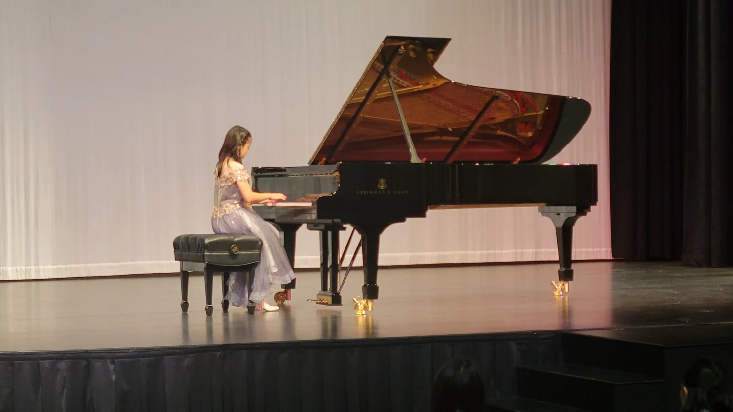 A Heart Beats pianist performing at a concert grand piano on stage