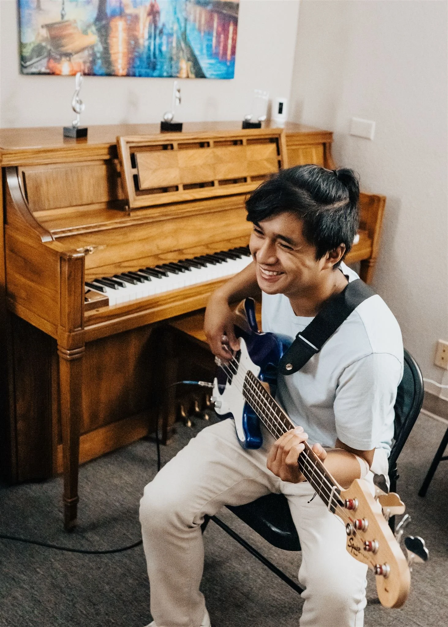A Heart Beats student smiling while playing electric bass