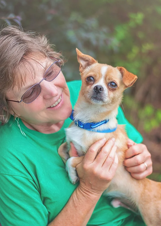 So we asked the volunteer, Susan, to hold him for a photo. This is a good way to show that, while he's scared, he's still loving. He's not a dog who will bite when he's picked up. He just needs a patient person to help him get settled. He's scared, but willing to relax, and that's what I want to show in his photos. Since he was a tougher one, I spent maybe 5 minutes on his pictures. Still not a long time at all. I had one person sitting with him on the bench and one standing behind me to help get his attention. 