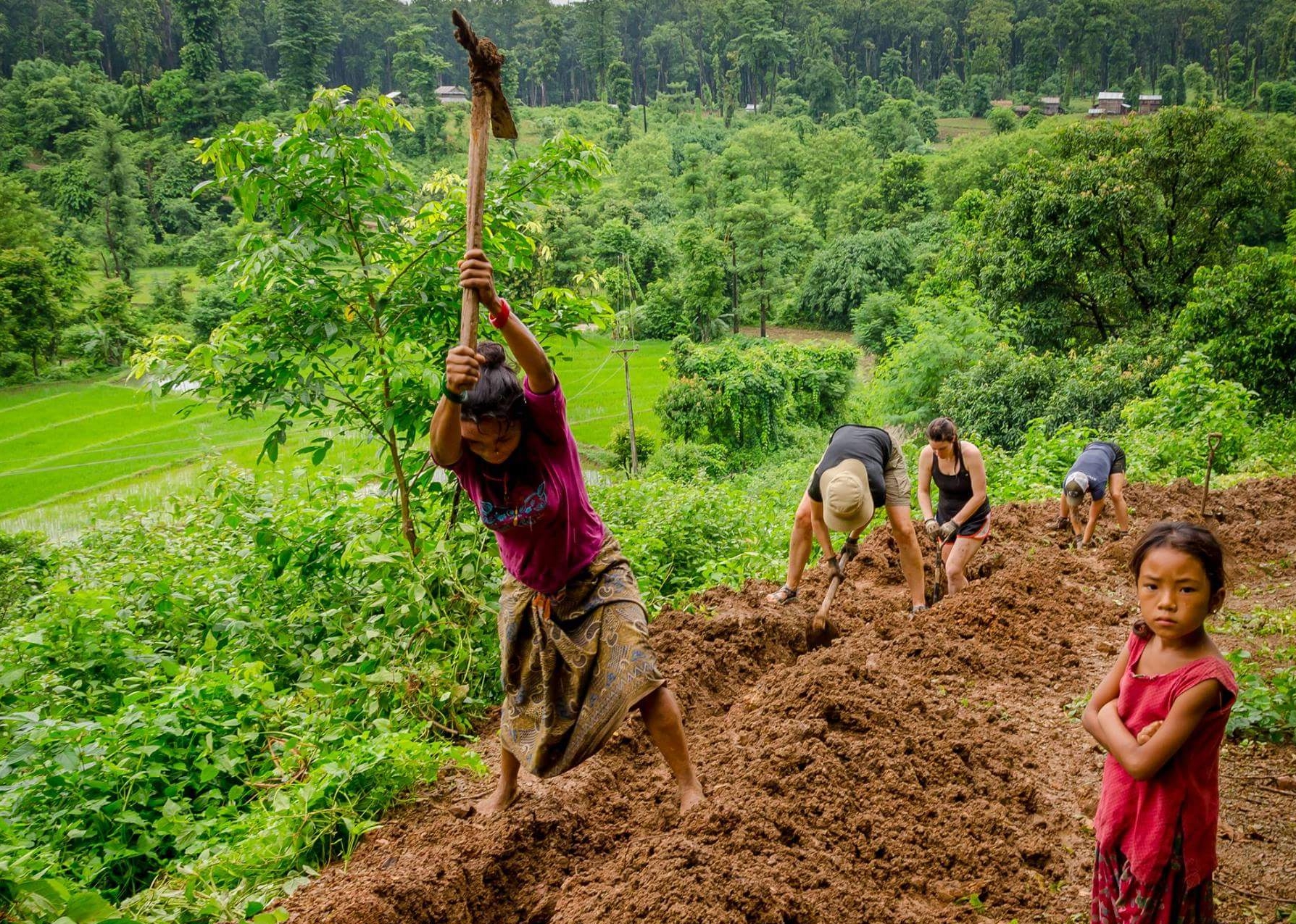 Local women and volunteers dig paths for pipelines in Nepal.