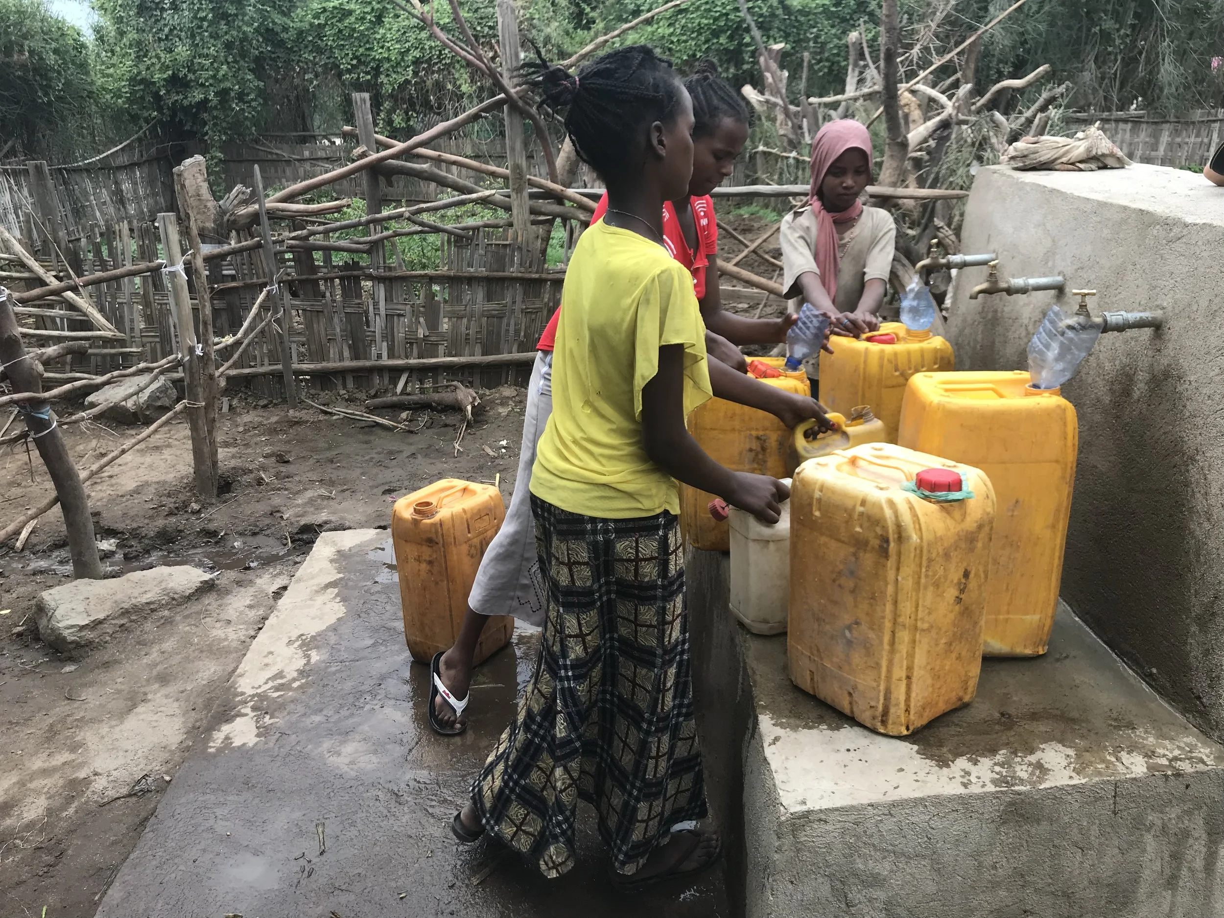Fig. 6 Jerrycans being filled at new tap stand in Andulala.