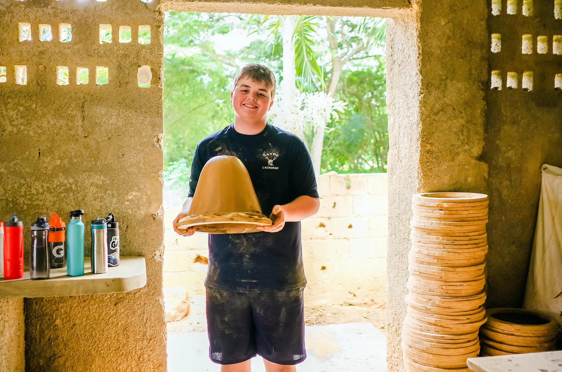 Neo Sanders showing off a ceramic water filter he made in the Dominican Republic