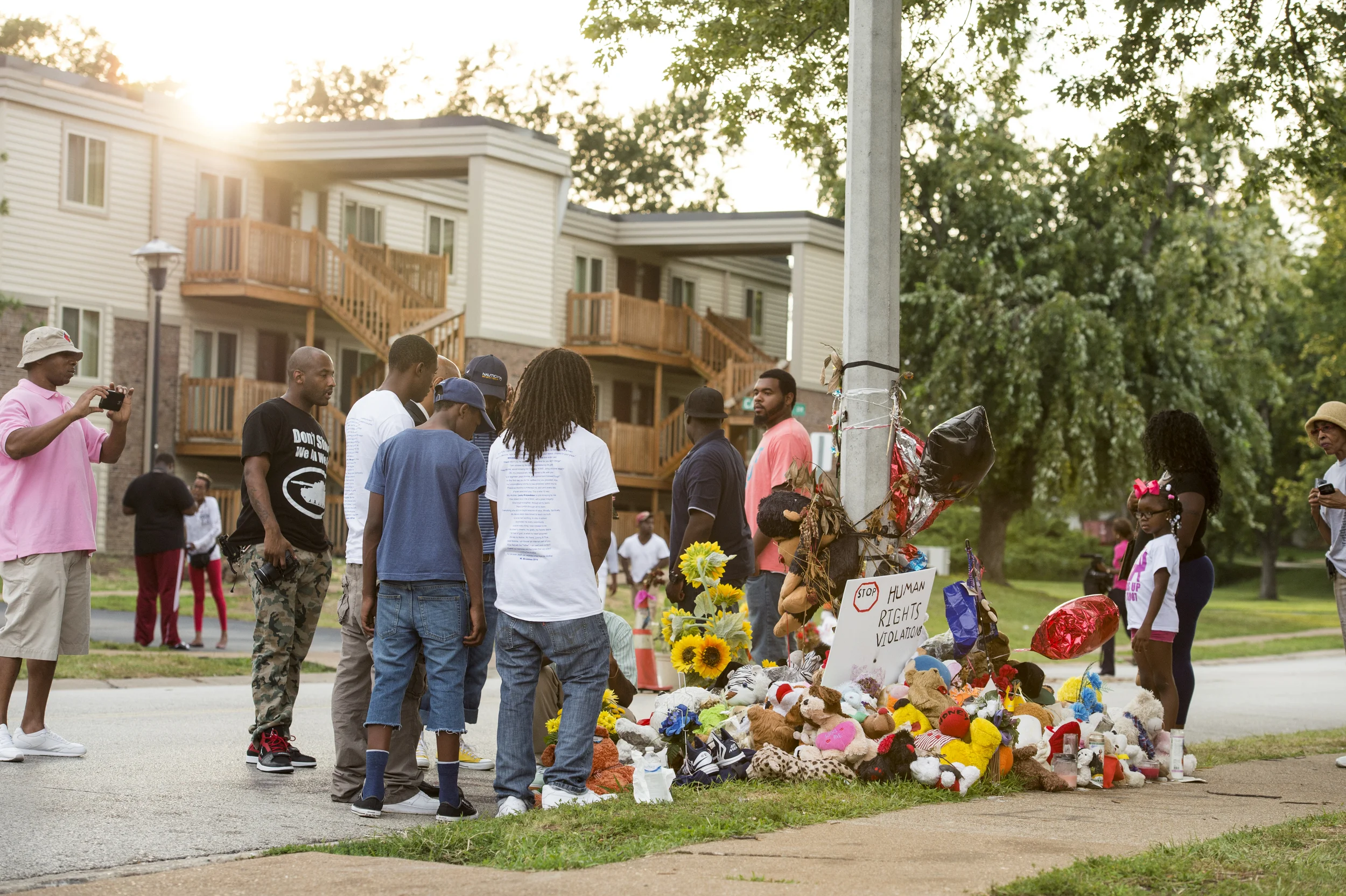 FERGUSON, MO/USA - AUGUST 30, 2014: A crowd gathers at makeshift memorial near where black teenager Michael Brown was shot to death by police in Ferguson, Missouri.