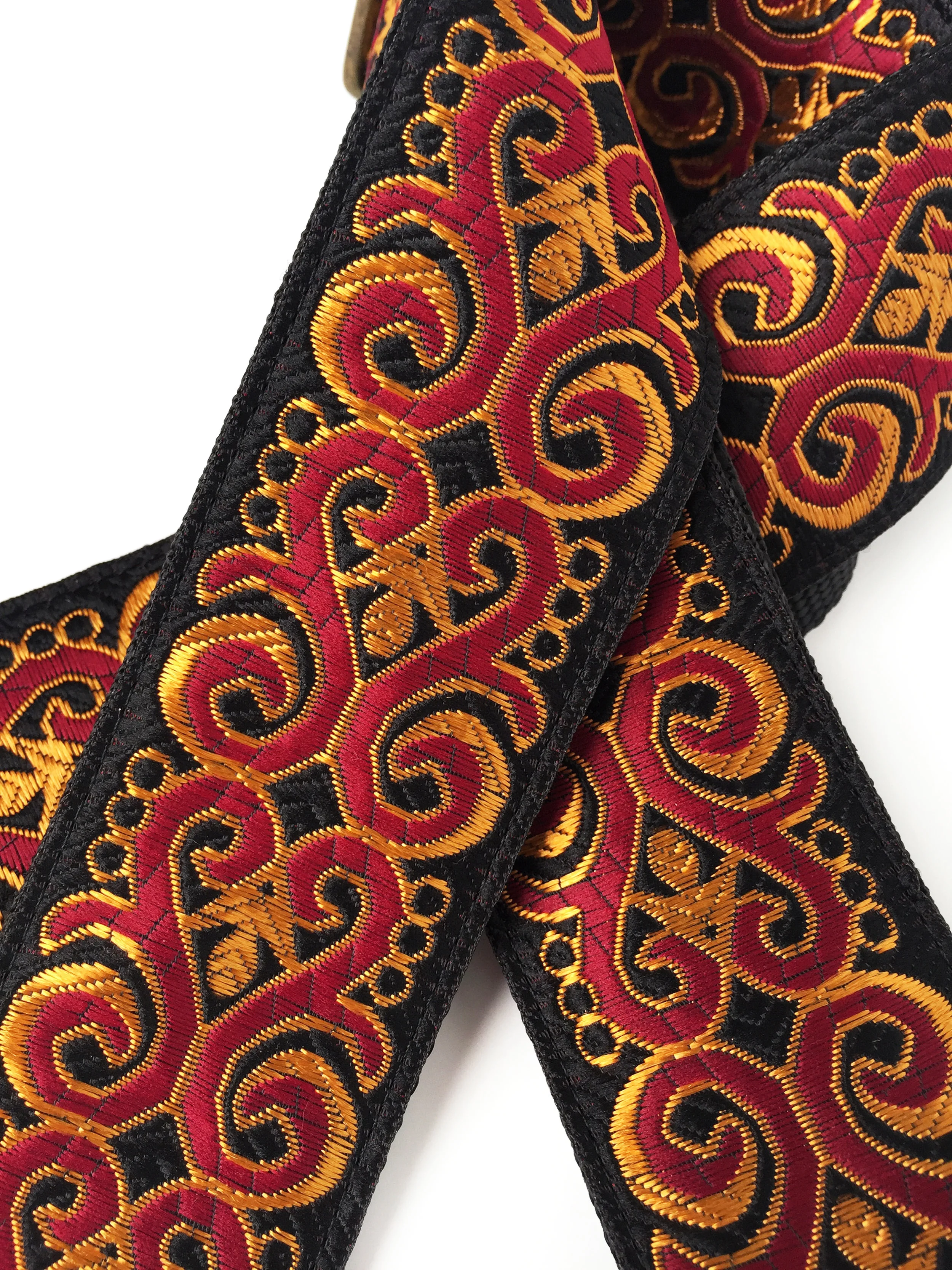 Burgundy, gold and black Diablo guitar strap closeup