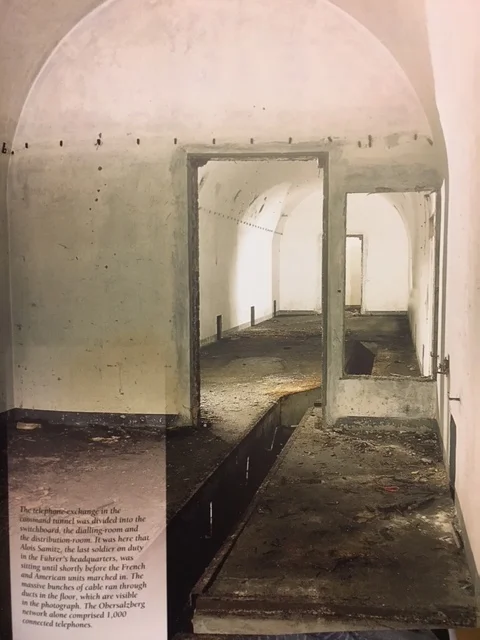 "The telephone exchange in the command tunnel was divided into the switchboard, the dialling room and the distribution room. It was here that Alois Samitz, the last soldier on duty in the führer's headquarters was sitting until shortly before the French and American units marched in. The massive bunches of cables ran through ducts in the floor, which are visible in the photograph. The Obersalzberg network alone comprised 1,000 connected telephones." Source: Hitlers Berg. Licht ins Dunkel der Geschichte: Geschichte des Obersalzbergs und seiner geheimen Bunkeranlagen, Florian M. Beierl 