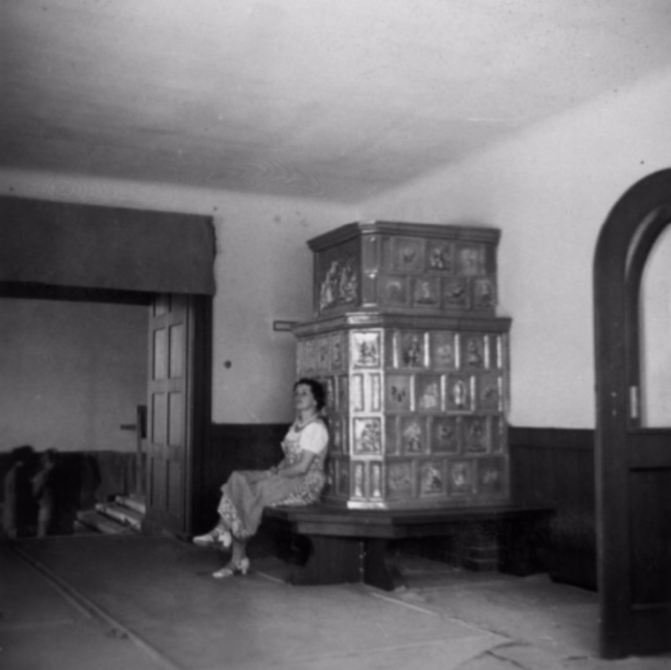  Munich artist, Sofie Stork, photographed next to the newly-installed  kachelofen , in 1936.  