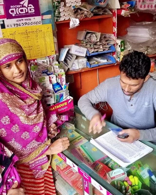 SAJIDA’s client paying her loan installment at a trusted merchant and rocket agent in her neighborhood. She is able to pay her loan installments showing just her ID card in a matter of minutes. #optixproject #mobilemoney #bangladesh #fintech #financialinclusion #dhaka #sajidafoundation