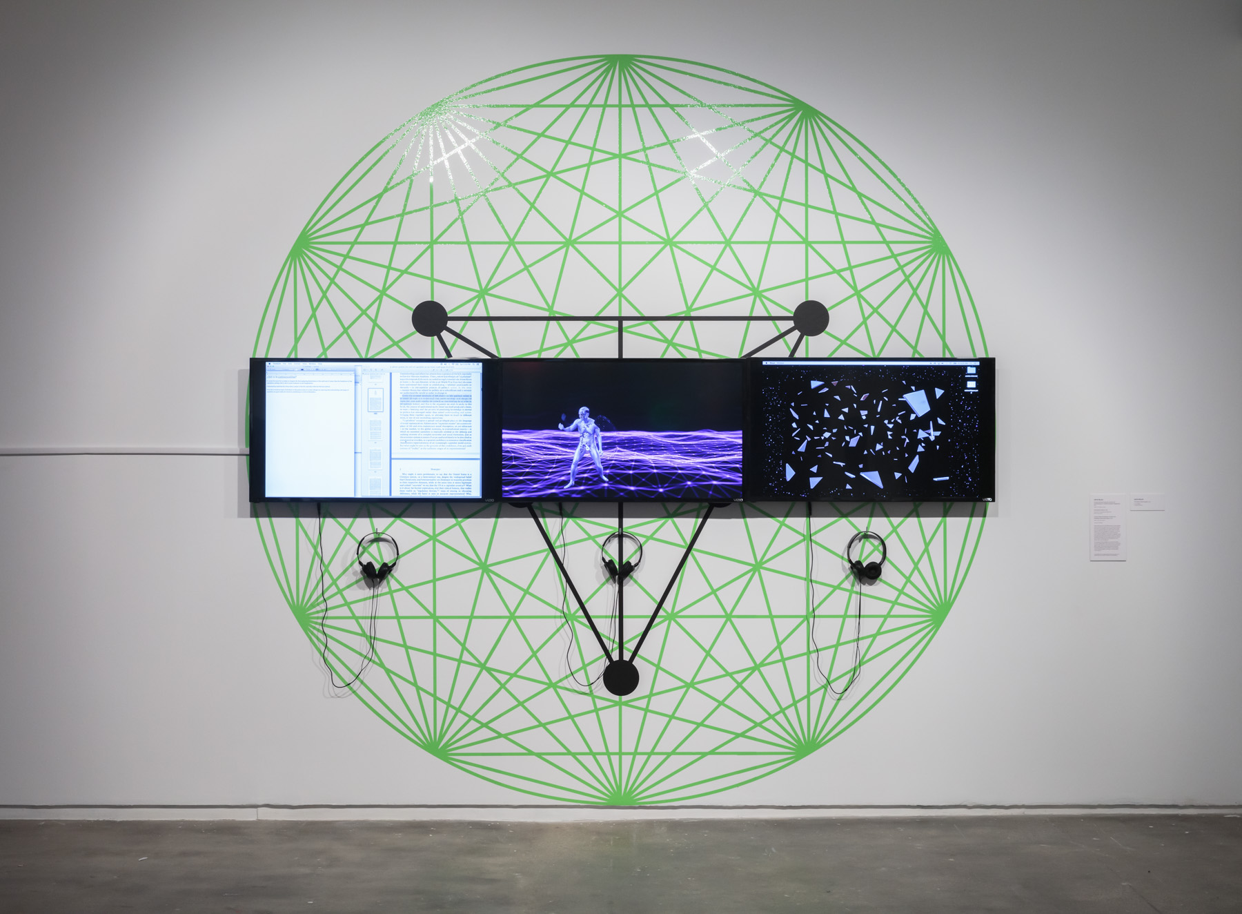 Zach Blas, Contra-InternetInversion Practice #1: Constituting an Outside(Utopian Plagiarism) , 2015. Video, 5 min. 58 sec., sound; Nootropix’s Dance , 2018. Video, 4 min., sound; Contra-InternetInversion Practice #3: Modeling Paranodal Space , 2016. Video, 3 min. 2 sec., sound; and The Seal of the Present , 2019. Vinyl installation. Courtesy of the artist. Installed in Refiguring the Future , Hunter College Art Galleries, 2019. Photo by Stan Narten.