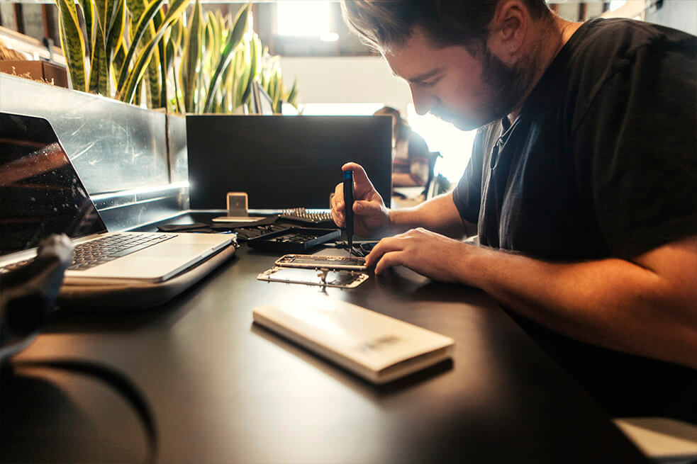 Travis Thomas fixing an iphone at the impact hub in state street santa barbara 03.jpg