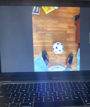 Coach Justin demonstrating soccer activities via video chat to youth players