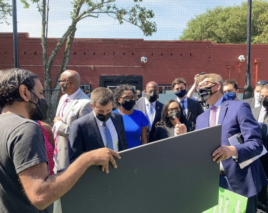 Members of the East Point City Council join U.S. Senator Jon Ossoff, U.S. Rep Nikema Williams, U.S. Transportation Secretary Pete Buttigieg, East Point Mayor Deana Holiday Ingraham, Sanjay Patel, director of strategic projects with Soccer in the Streets, U.S. Senator Reverend Raphael Warnock and MARTA CEO Jeff Parker