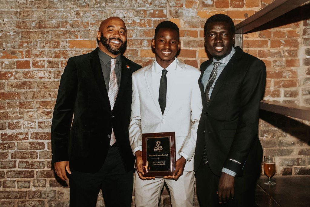 Director of Programs Tony Carter and Clarkston Coach Adam Adam presenting award to Moses