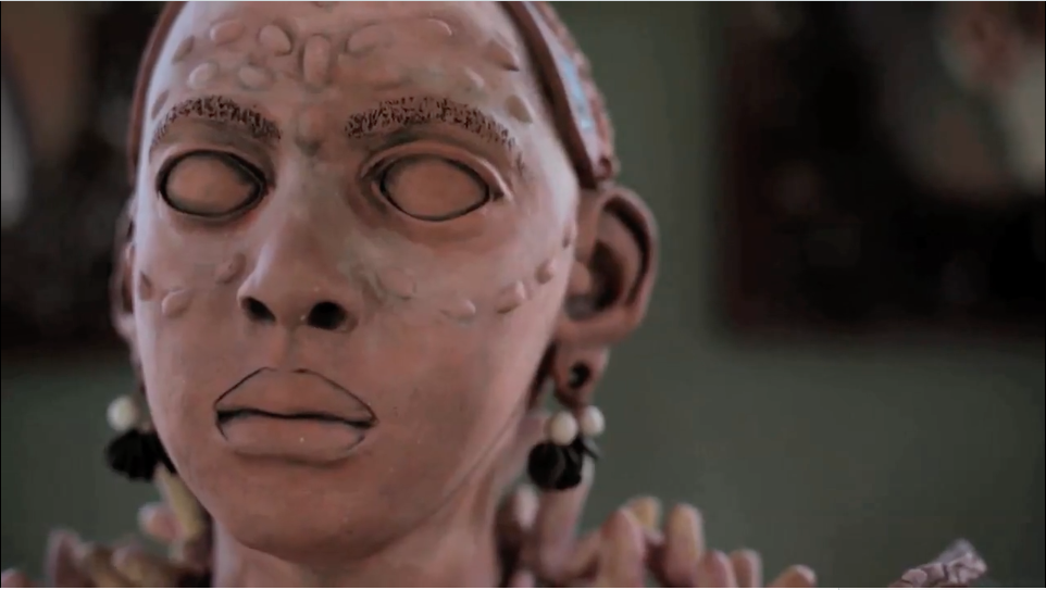 Sculptural head of a black woman with braids.