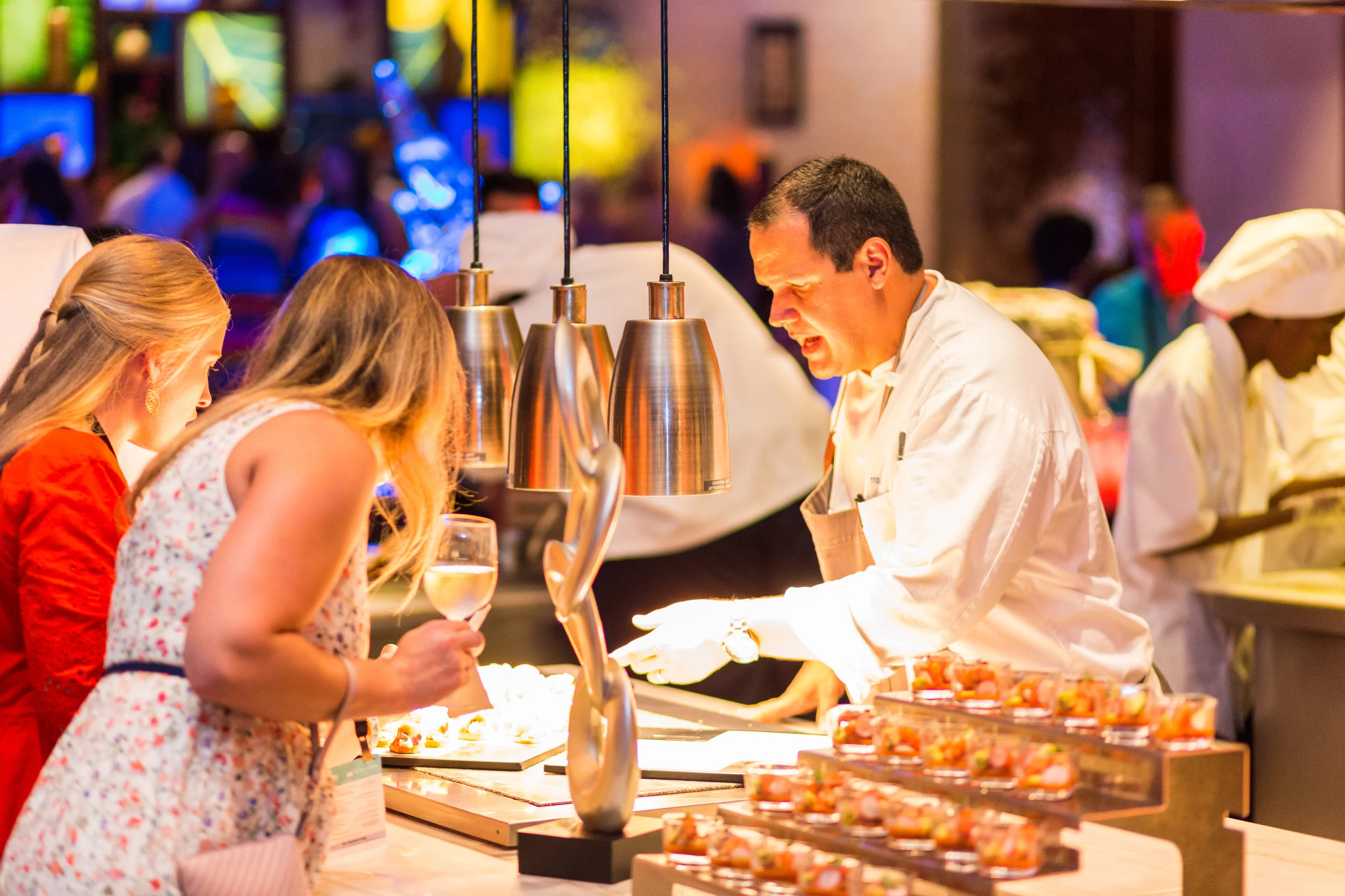 An Atlantis chef explaining his dish to inquisitive attendees.