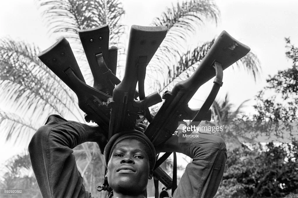 A Biafran Soldier Holding Guns.