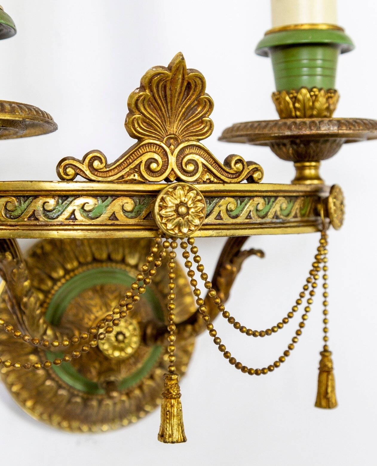 Here is a close-up shot of one of a pair of cast brass, double light, gold, and green Neoclassical wall sconces with Egyptian Revival wave details. Finely made by Lion Electric Co. in 1924, with solid brass tassels and switches on the decorative moun