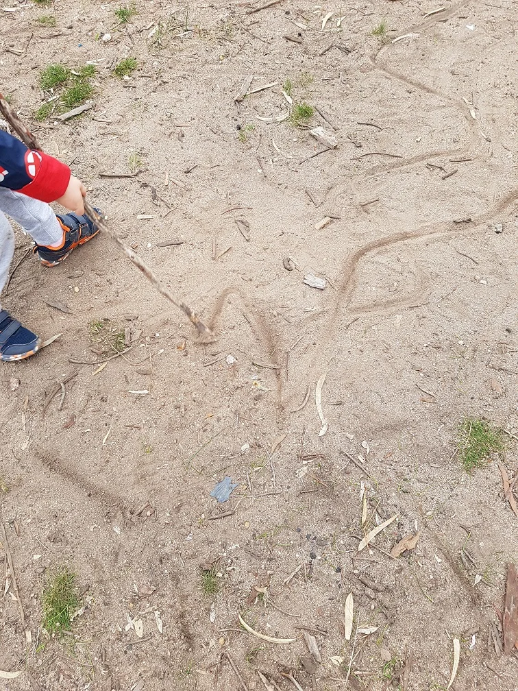 A stick becomes a giant pencil...drawing a river in the dirt