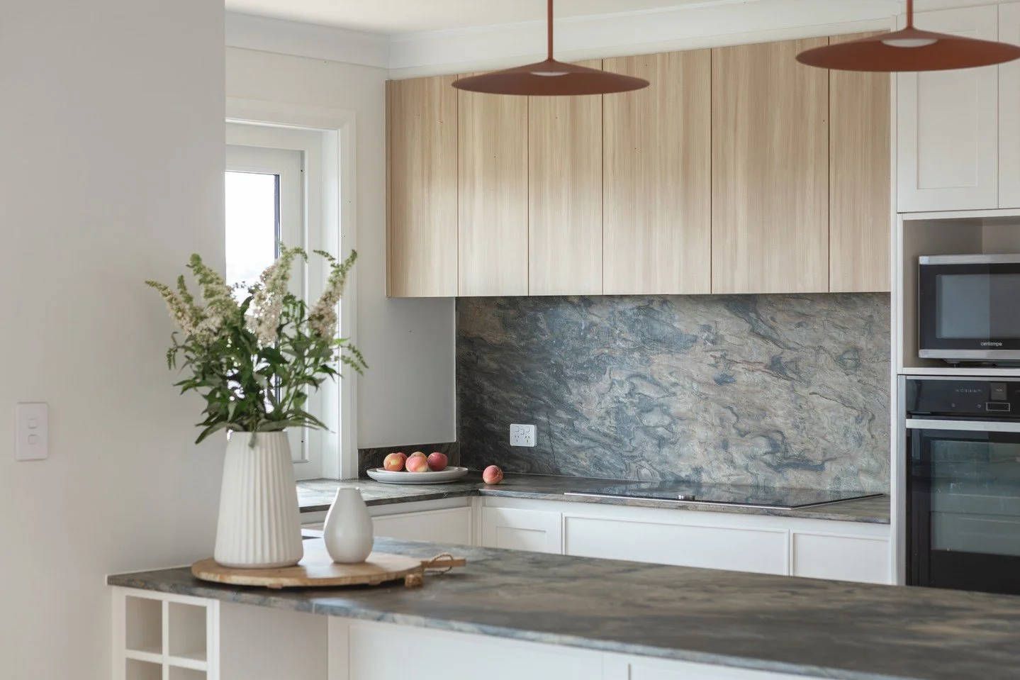 MATERIALITY :: Coastal in tone. Considered in detail.⁠
⁠
Stone as anchor.⁠
⁠
Timber as warmth.⁠
⁠
Veining as artwork.⁠
⁠
A textural fireplace grounds the living zone, while expressive natural quartzite wraps the kitchen in depth and movement.⁠
⁠
Key 