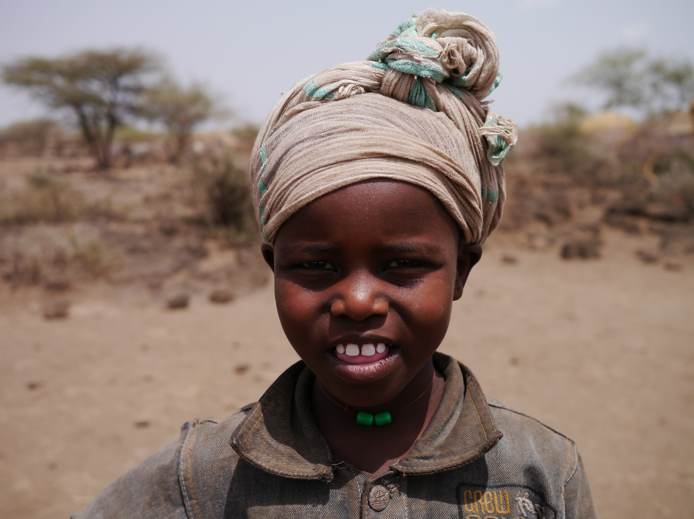 As I stood on the edge of the village the other children ran off and this girl emerged from the bush. I pointed to myself and said my name, then pointed at her shoulder. She said, “Jacket” in English. Not believing what I heard, I repeated the gesture. Sure enough, again she said, “Jacket”. I picked up a stick and started to write in the dust letters and then words that I know are on the tablets. One by one she read them all.