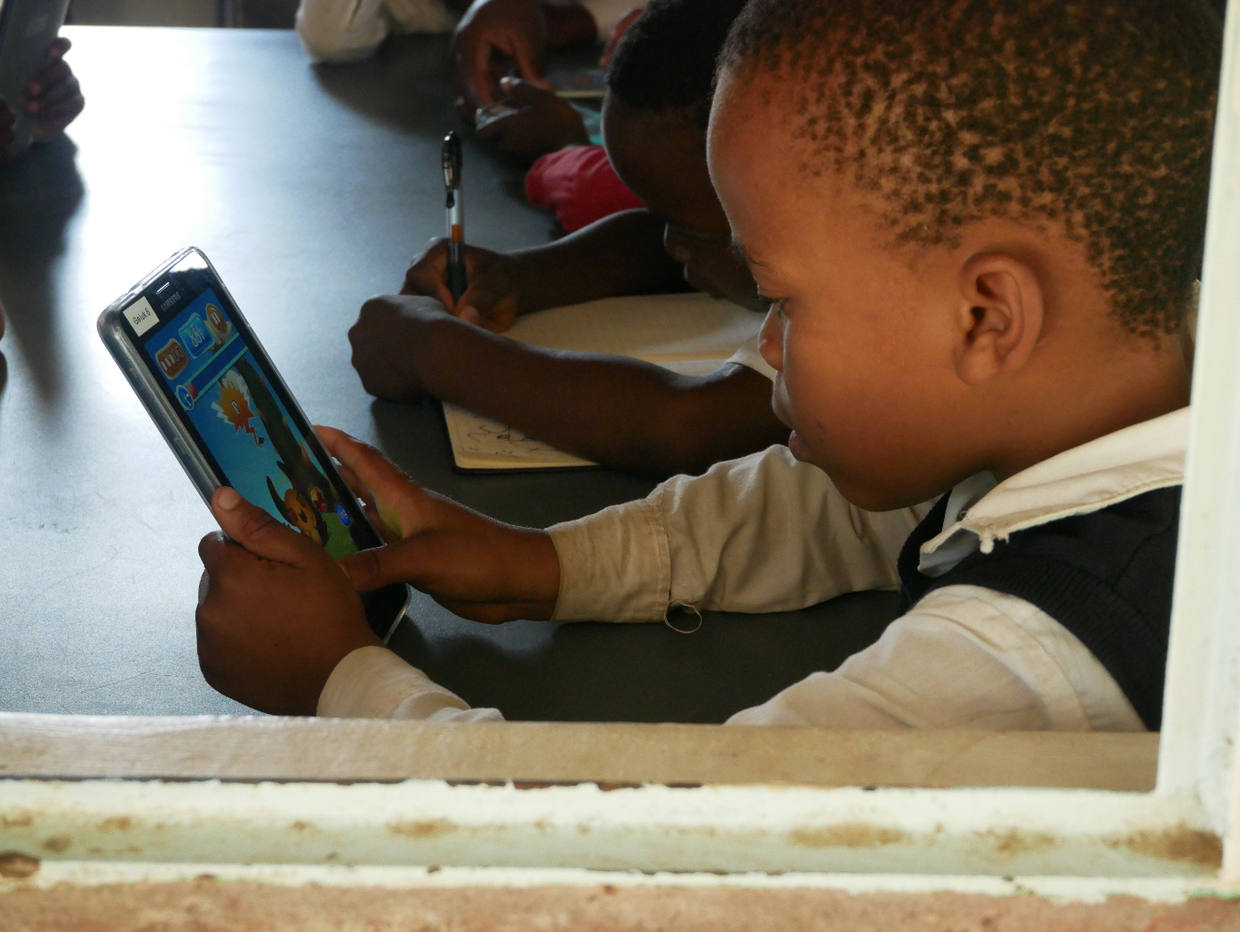Early testing of Feed the Monster. This girl is using the isiZulu version of the Feed the Monster app that teaches early literacy skills. This app is now available in all 11 official South African languages.