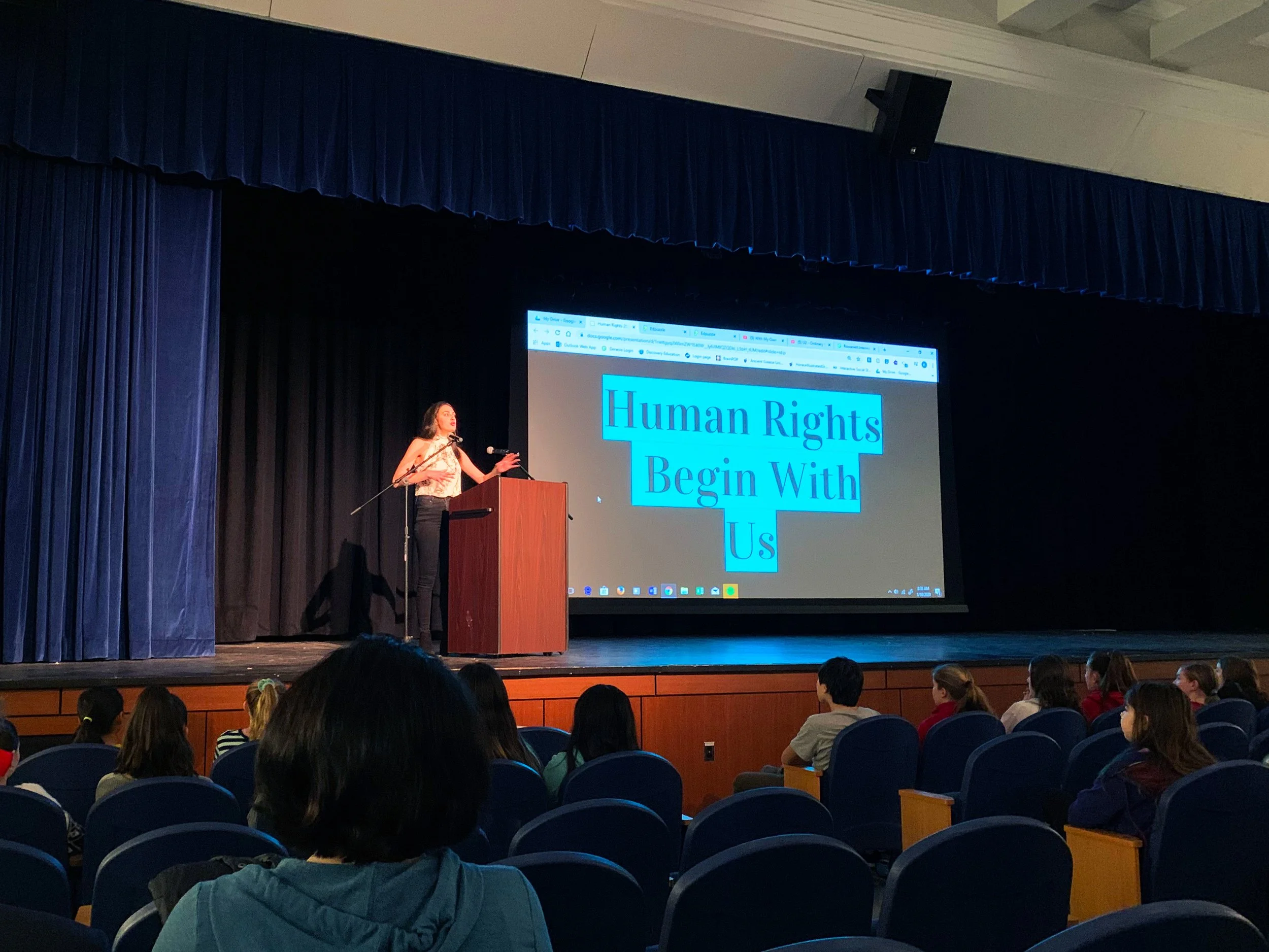 Alex presenting to students in an auditorium.
